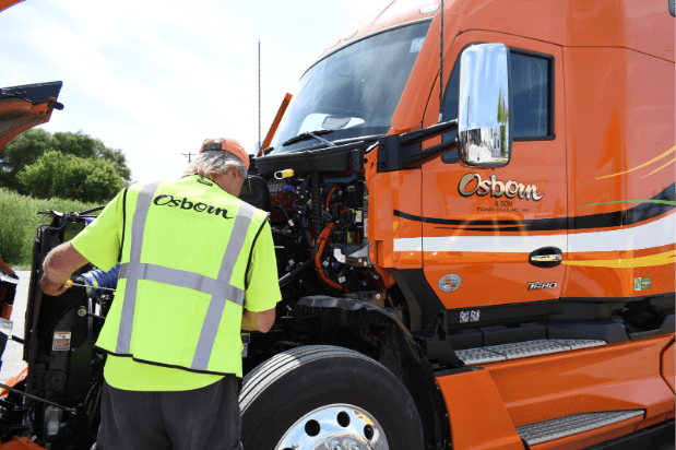 An Osborn driver checks his oil during his pre-trip inspection, showcasing his commitment to safety